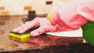 cleaning countertop with sponge