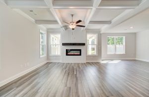 great room with farmhouse electric fireplace and coffered ceiling