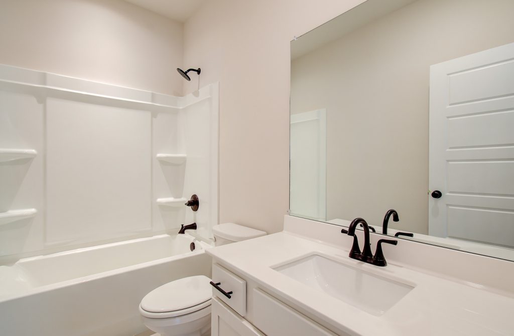bathroom with vanity and shower and tub with black hardware