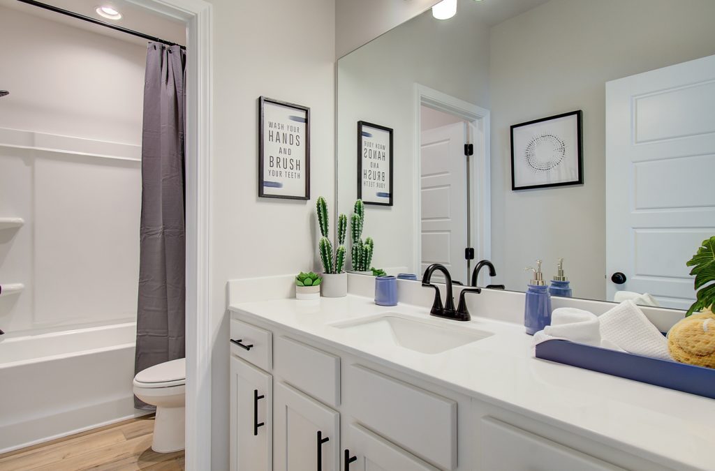 bathroom with white cabinets and black hardware