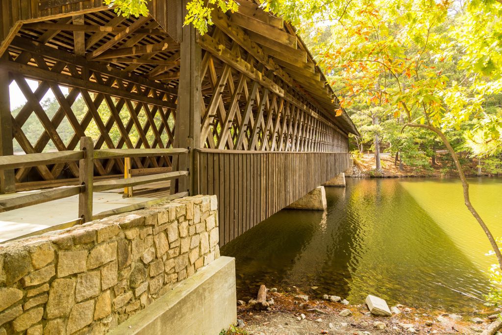 Covered bridge crosses Stone Mountain Lake to Indian Island in Stone Mountain Park in Georgia.
